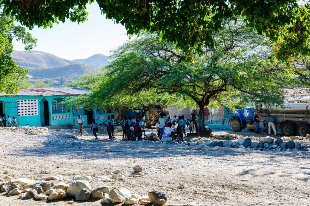 Hatian students gather in the shaded school yard near Gonaives, Haiti.