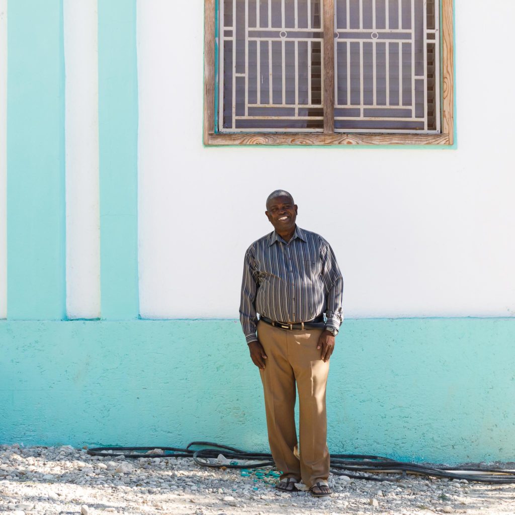 Pastor Delamy poses ouside a his office building in Terre Blanche, Haiti.