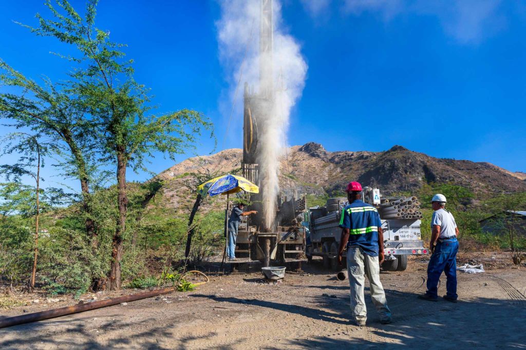 Water well drilling starts with a cloud of dust billowing into the air near Gonaieves, Haiti.