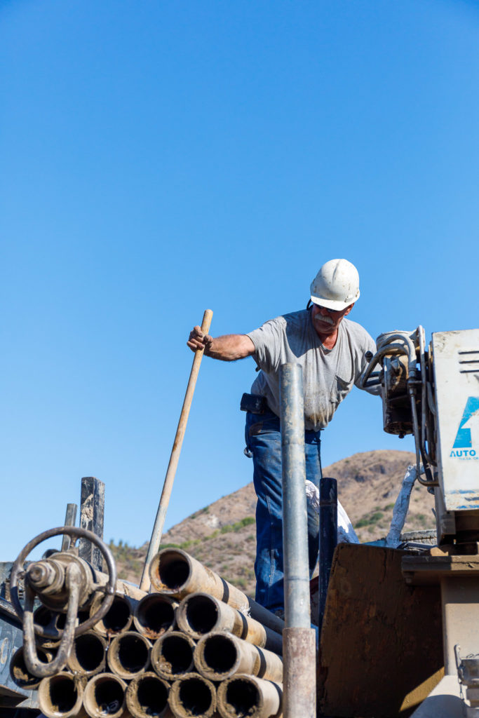 Kevin gathers tools for drilling on top of the water truck.