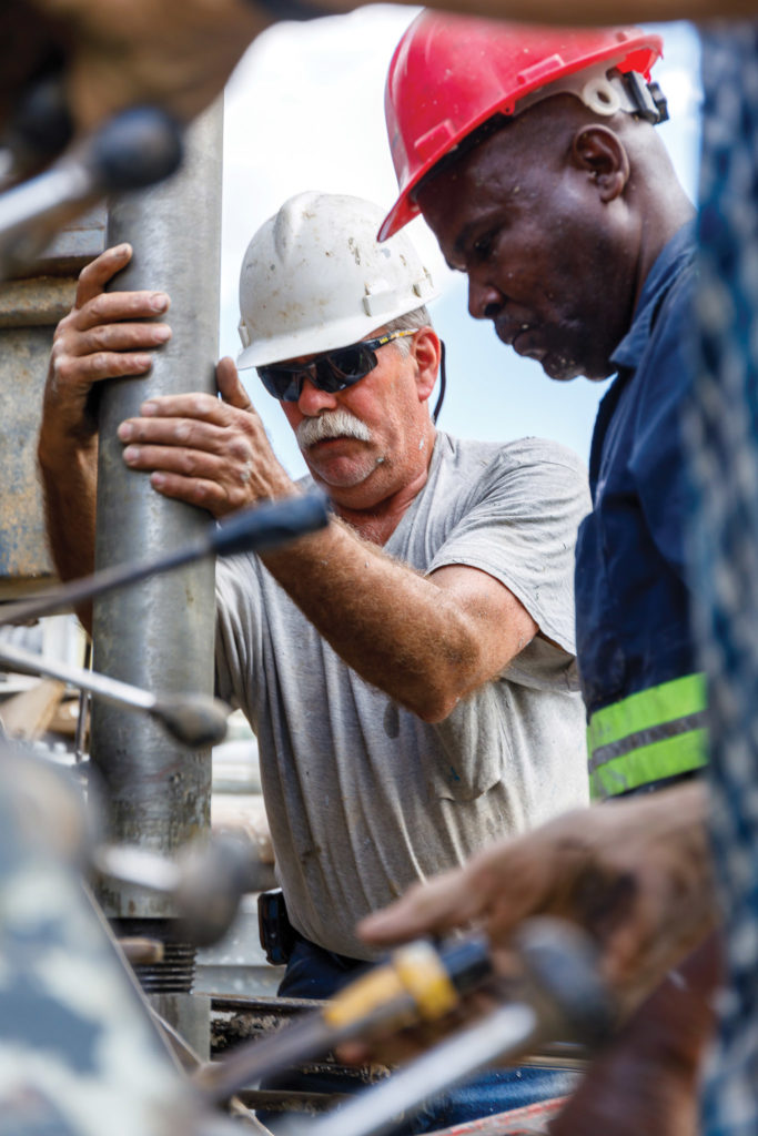 Water Well drillers attaching pipe as they dig a well near Terre Blanche, Haiti.