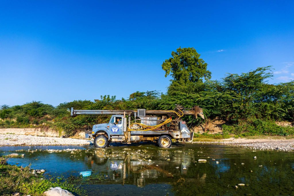 Water for Life drilling rig crossing a shallow river.