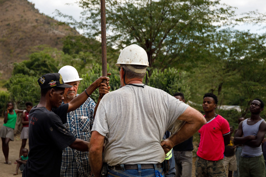 Locals watch as workers repair a well in Terre Blanche, Haiti.