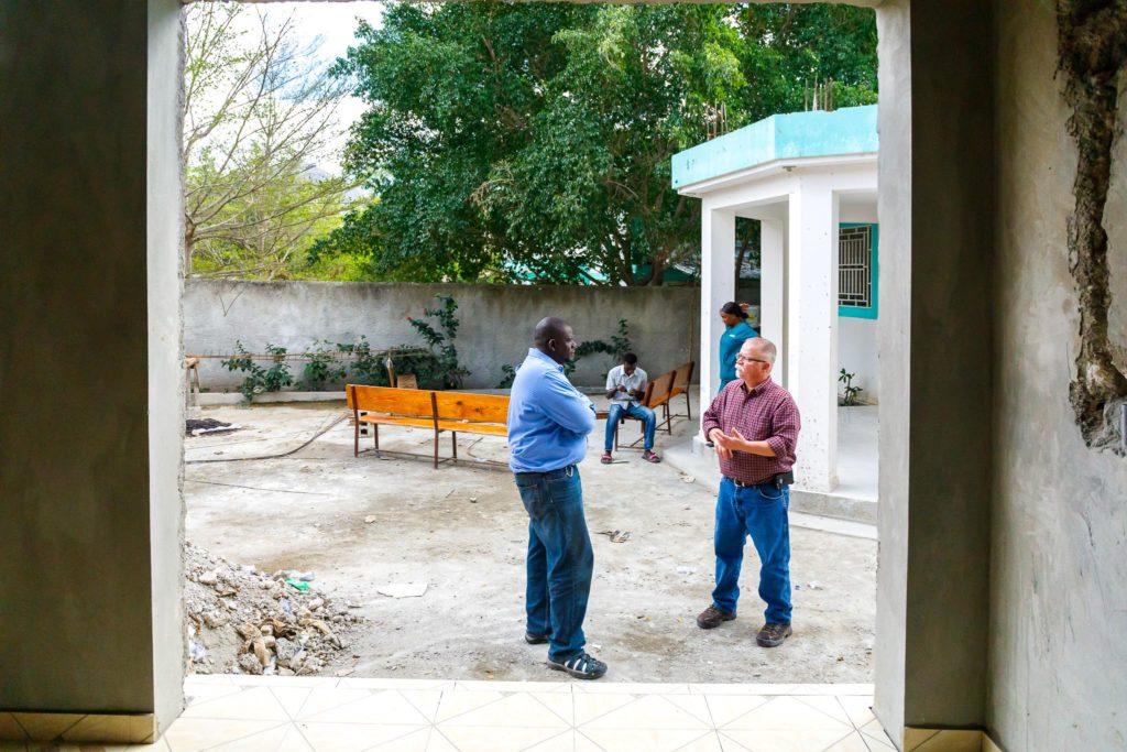 Phil Barkman and grounds keeper converse outside a clinic in Terre Blanche, Haiti.