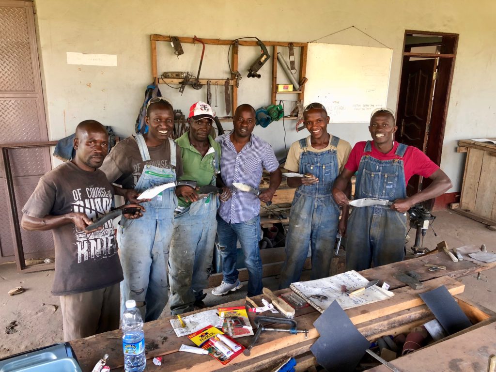 Bamba Forge workers proudly display knives they have made in thier workshop.