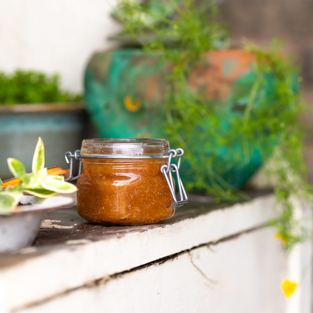 Home Made Gardeners Hand Scrub on white potting bench with flowers