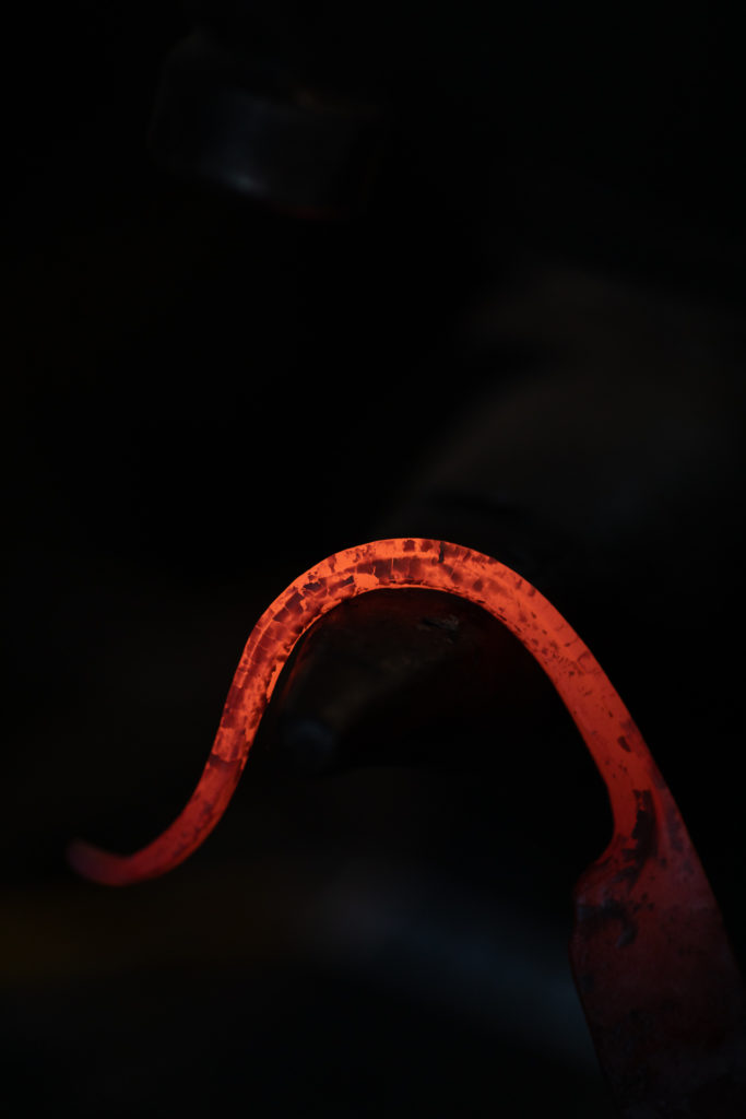 Glowing metal being bent into a knife handle