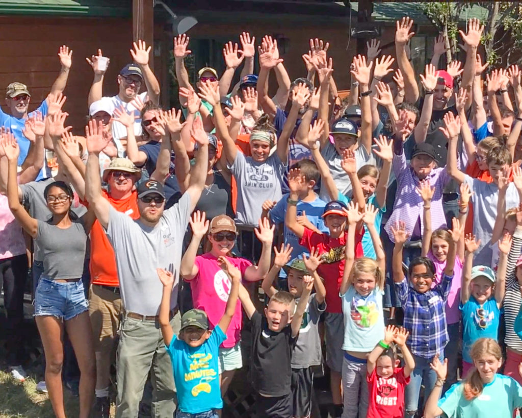 Volunteer Workers raising both hands after volunteer project for widows