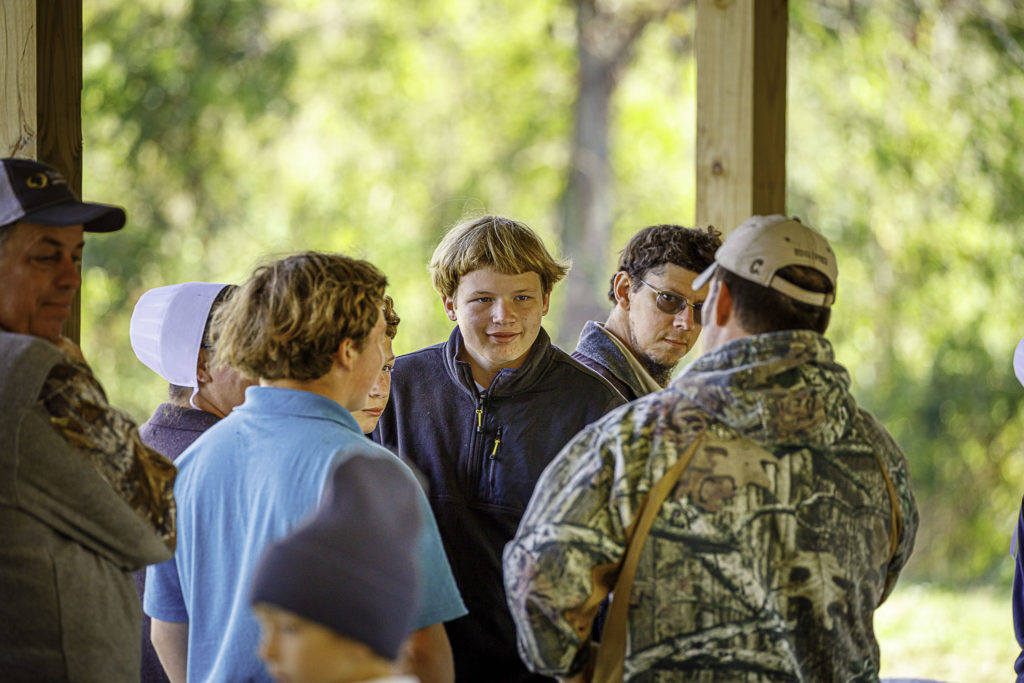 Young Amish boys listen intently as a guide in camo tells a story.