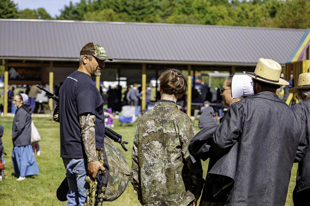A volunteer talks with an Amish family as they prepare for their son to go hunting later that day.