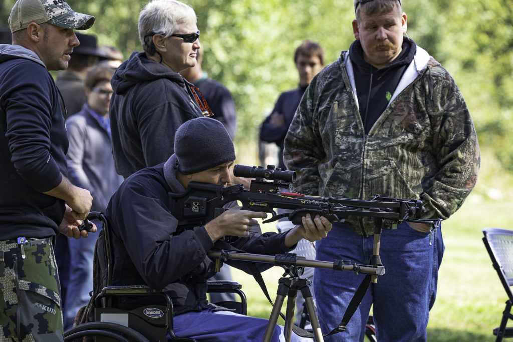 A young wheelchair bound hunter takes aim as he practices shooting his crossbow.