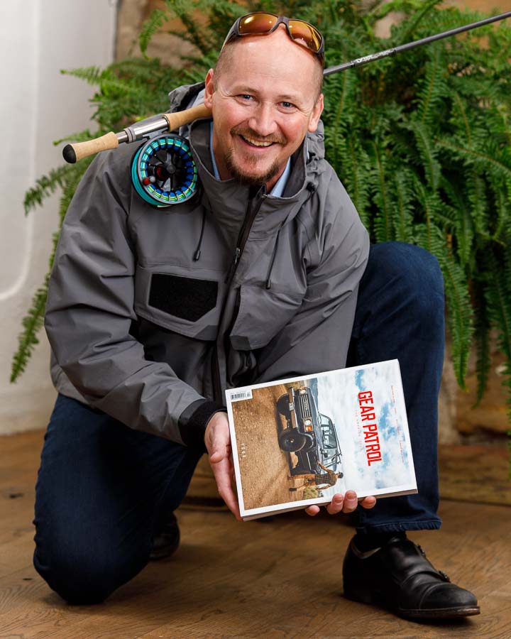 Marlin Miller portrait with flyfishing gear and Gear Patrol Magazine in Plain Values Office