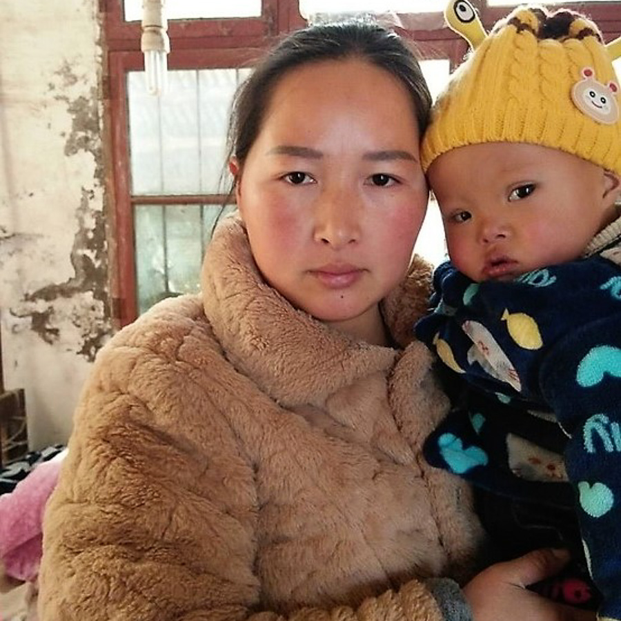 Young Chinese mother holds her child in winter.