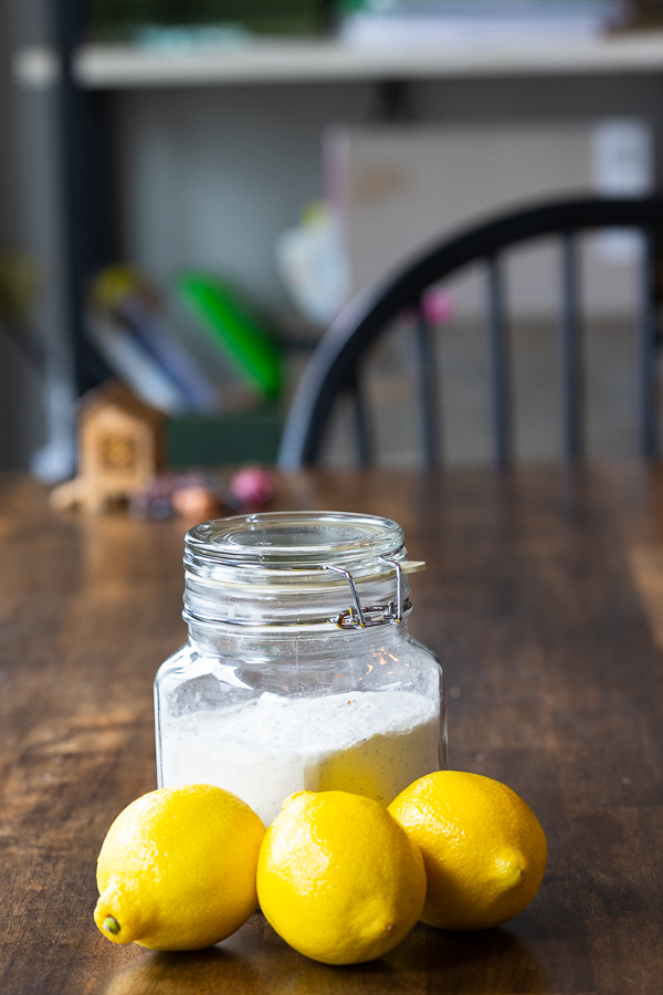 Lemon Poppy Seed mix on wooden table behind three lemons.
