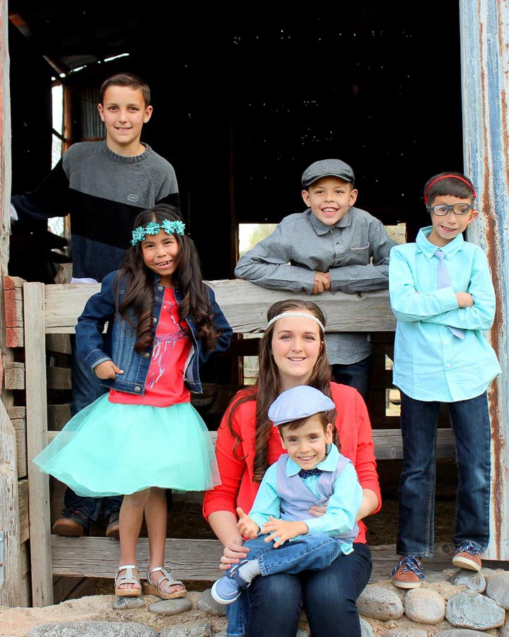 The gagnon children are all dressed up in front of a barn when the children were much younger.