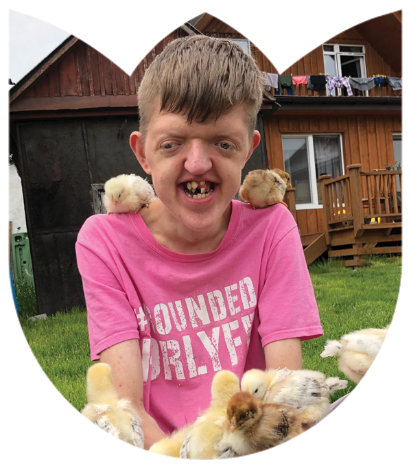 One of the children from Wide Awake International sitting with chickens