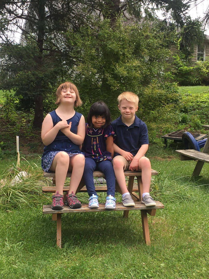 Elli, Ana, and Levi Sanders sitting on a picnic table