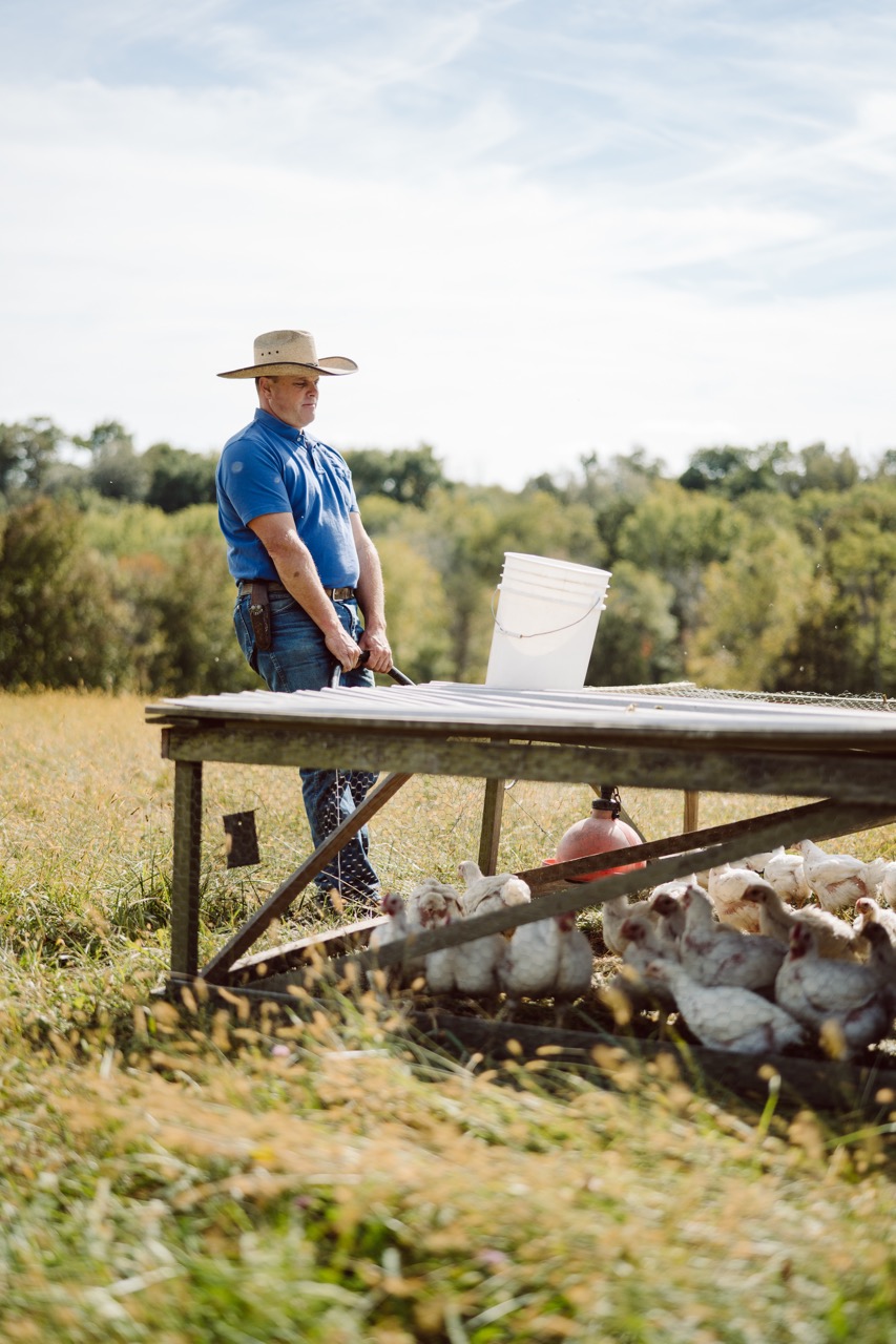 Daniel Salatin, Joel's son, moves a mobile chicken shelter